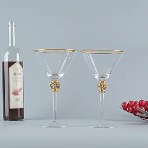 Vista macro dettagliata di due bicchieri da martini con bordo dorato e stelo in diamanti