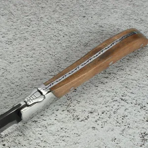 Detalle macro del mango del cuchillo de carne Laguiole con madera de olivo y abeja