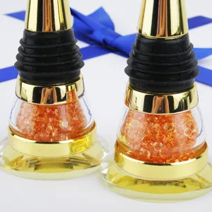 Close-up of elegant gold wine bottle stoppers with orange crystal bead filling and ribbon
