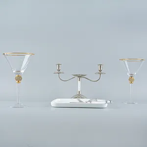 Eleganti bicchieri da martini con bordo dorato e steli con diamanti su una tavola.