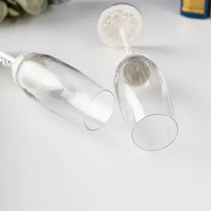 Gros plan d'élégantes coupes à champagne en cristal avec nœud blanc et strass