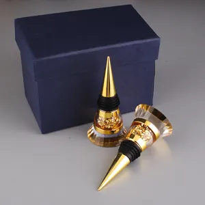 Macro view of two elegant gold wine stoppers and a premium dark blue gift box display