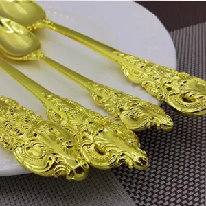 Macro detail of vintage palace-style golden cutlery handles with embossed patterns.