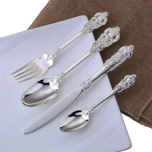 Detailed macro view of vintage palace-style silver cutlery set with intricate floral engraving