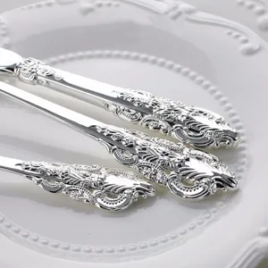Macro detail of vintage palace style silver-plated cutlery with ornate floral carvings