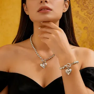 Primo piano di elegante set collana e bracciale di perle argentate con pendente a cuore su modella