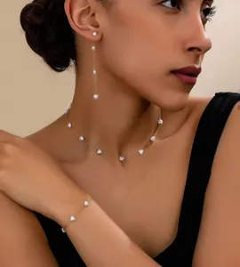 Elegante set di gioielli tre pezzi con perle a forma di cuore su sottili catene dorate