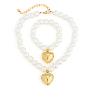 Elegante set collana e bracciale di perle finte con ciondoli a cuore dorati per donne