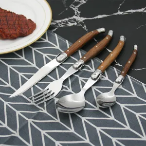 Laguiole style 4-piece cutlery set with wood handles on a patterned napkin
