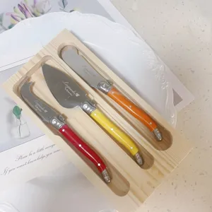 Detailaufnahme des Laguiole Käsemesser-Sets mit bunten Griffen in einem Holztablett