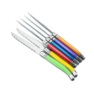 Close-up view of six colorful Laguiole steak knives with serrated stainless steel blades.