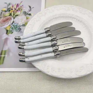 Juego de 6 cuchillos para mantequilla Laguiole en acero inoxidable con mangos blancos en un plato
