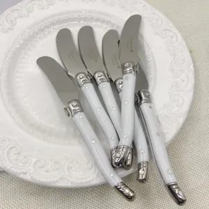 Primer plano de cuchillos para mantequilla Laguiole de acero inoxidable con mangos blancos