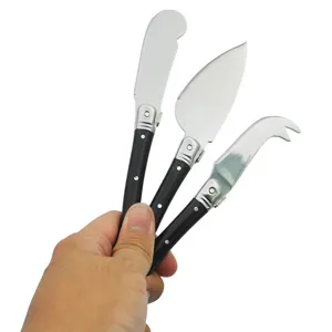 Nahaufnahme des 3-teiligen Laguiole Käsemesser-Sets in Schwarz, in der Hand gehalten