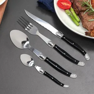 Macro view of a 4-piece French style cutlery set with black handles and bee emblem