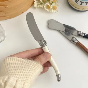 Detalle de cuchillo para mantequilla estilo Laguiole con mango crema y hoja de acero