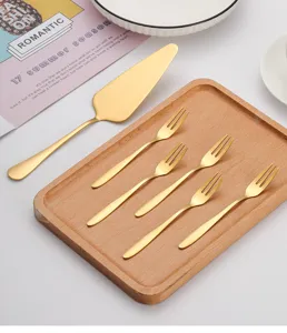 Vue détaillée de l'ensemble pelle à gâteau et fourchettes à dessert dorées sur plateau