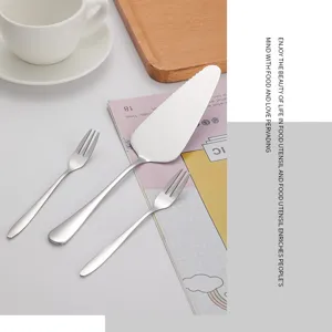 Détail d'une pelle à gâteau en inox poli et de deux petites fourchettes