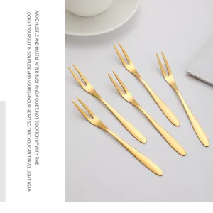 Lot de cinq élégantes fourchettes à dessert en inox doré sur un fond minimaliste épuré