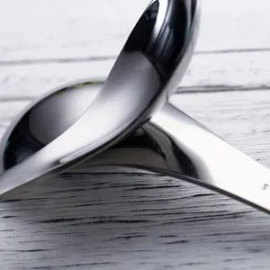 Close-up detail of thickened stainless steel soup spoon with mirrored polished finish.