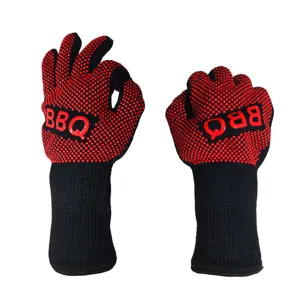 Close-up detail of heat-resistant BBQ gloves with red silicone dots and black knitted fabric.