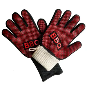 Detail close-up of heat resistant BBQ gloves featuring red silicone dots and long knit cuffs.
