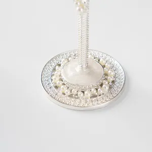 Gros plan du pied d'une coupe de champagne de mariage avec perles et gravures argentées