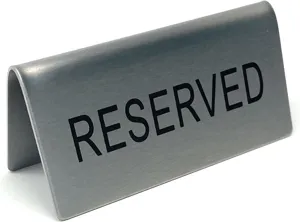 Gedetailleerde close-up van een geborsteld roestvrijstalen tafelbord met RESERVED-tekst