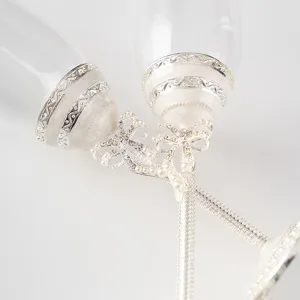 Gros plan de flûtes à champagne de mariage élégantes avec nœuds blancs et strass