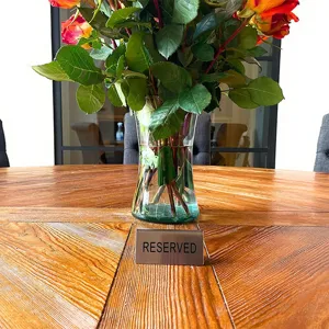 Detailopname van een gereserveerd tafelbordje van roestvrij staal in een restaurant