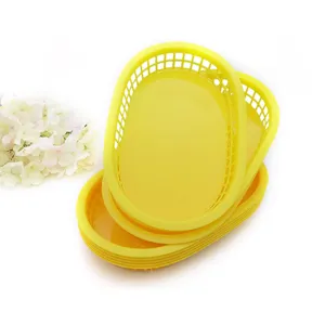 Close-up view of stacked yellow oval plastic snack baskets for hot dogs and fried food