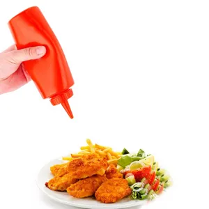 Bouteille à presser en plastique rouge pour ketchup sur une assiette de nourriture