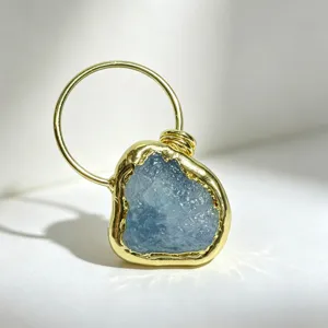 Detailopname van ruwe aquamarijn hanger met onregelmatige 14K goud vergulde zetting