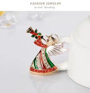 Vista detallada de un broche de ángel de Navidad con esmalte rojo verde y pedrería