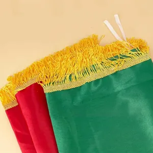 High-quality detail of yellow fringe on vibrant green and red Kurdish satin flag