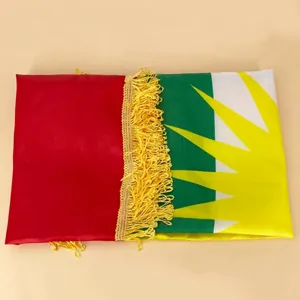 Detail shot of the Kurdish flag featuring golden fringe and a vibrant sun emblem