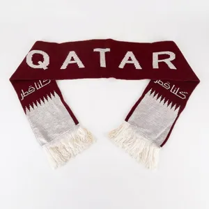 Detail view of 16x135cm Qatar flag knitted jacquard acrylic scarf in maroon and white.