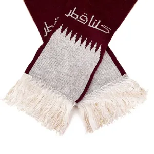 Close-up detail of Qatar national flag knitted scarf with maroon and white fringe texture