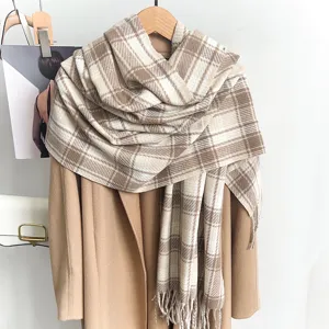 Detailed macro view of a brown and white plaid winter scarf with classic fringe details