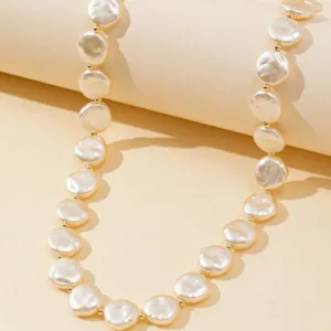 Collana minimalista a strato singolo con perle barocche piatte finte e grani dorati.