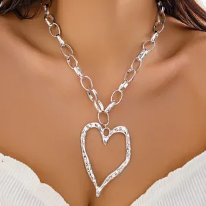 Detailed macro view showing the textured lava heart pendant on a silver chunky chain