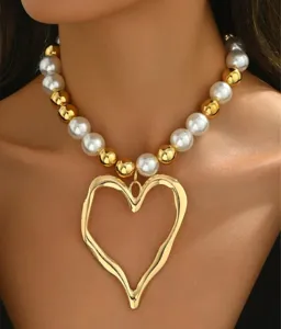 Close-up of baroque pearl necklace with oversized molten heart pendant in gold finish