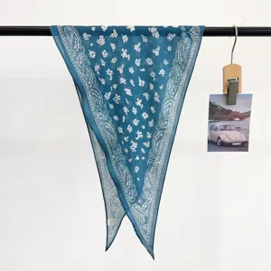 Macro view of blue vintage paisley floral pattern on a cotton rhombus headscarf