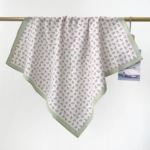 Detailed view of the soft texture and tiny floral print on this cotton square scarf.