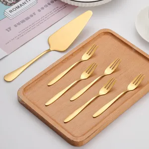 Élégant service à gâteau en acier inoxydable doré avec fourchettes sur un plateau en bois
