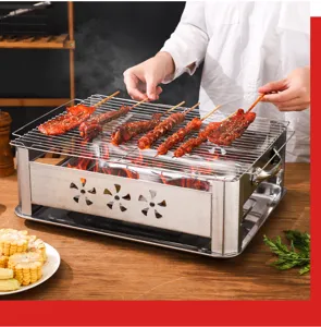 Action-Aufnahme beim Grillen von Fleischspießen auf einem tragbaren Holzkohlegrill