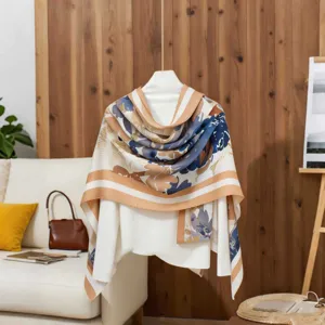 Detailed view of a floral cotton linen scarf draped over a white top in a cozy room.