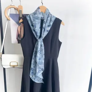 Hellblauer Chiffonschal mit Blumenmuster als Accessoire an einem schwarzen Kleid