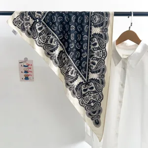 Gros plan sur un foulard triangulaire vintage à motif cachemire bleu sur chemise