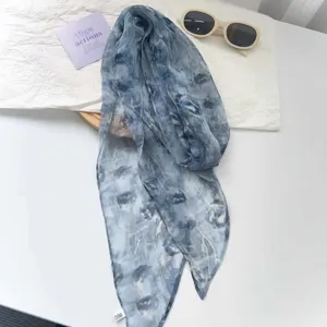 Nahaufnahme eines leichten Chiffon-Schals mit blauem Blumenmuster und weicher Textur